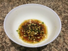 Trong thời gian luộc gà, trộn đều dầu mè với nước tương, tỏi băm và ít hành lá băm nếu thích. Thịt gà chín xả qua ít nước lạnh cho nhanh nguội rồi xé nhỏ.