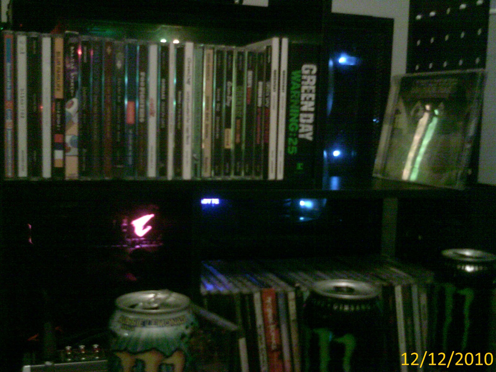 A rack of CDs, but the image is obscured by random shit like cans of monster