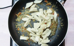 Cho 1 muỗng canh dầu ăn vào chảo, thêm sả ớt băm vào chảo xào thơm thì cho mì căn vào cùng.