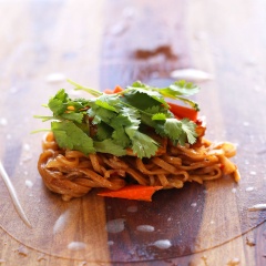 Đậu hũ cắt thành lát mỏng vừa ăn. Bắc chảo lên bếp, chảo nóng cho dầu vào chảo, dầu sôi lăn tăn cho tiếp đậu hũ vào chiên vàng giòn, vớt ra thấm ráo dầu. Cho phần còn lại của nước sốt vào trộn đều với đậu hũ, để lửa vừa khoảng 3-5 phút cho thấm. Trải bánh tráng mỏng lên thớt, cho 1 gắp bún xào, 1 gắp đậu hũ chiên vào, thêm cà rốt, hành lá, ngò rí lên trên cuốn tròn, dài chặt tay.