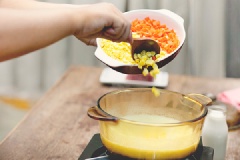 Đặt nồi hỗn hợp khoai lên bếp, cho cà rốt và bắp vào, đun lửa vừa.