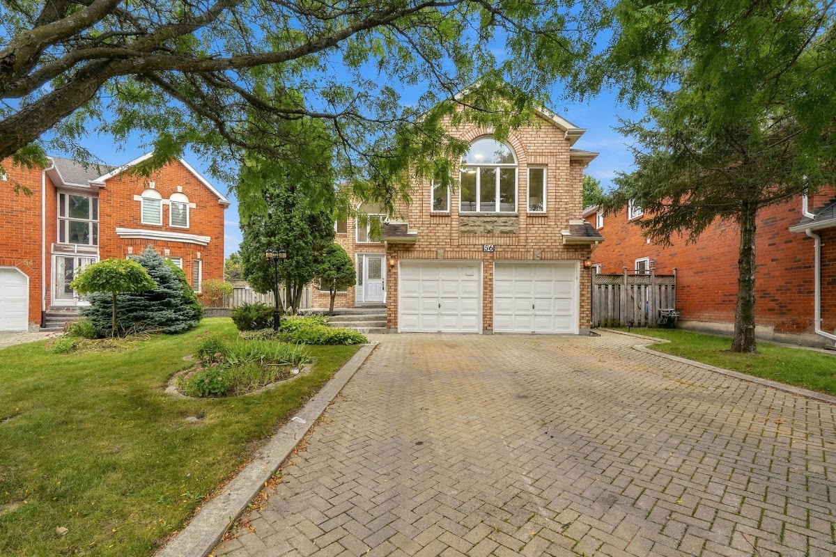 The front of the home from the court, under the mature tree