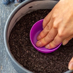 Cho hỗn hợp vào khuôn tròn 18cm, dùng vật nặng có đế bằng và ấn mạnh xuống cho bằng phẳng. Cho phần đế bánh vào tủ lạnh cho đến khi đông cứng lại. Lúc này ta chuẩn bị phần cheesecake.