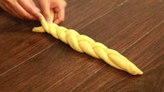 Khi đã tạo hình 3 phần bột, tiến hành tết thành bím rồi cuộn tròn lại để tạo thành hình bông hoa.