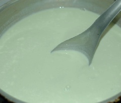 Đổ nước trà đã hòa tan vào sữa, cho 2 hộp sữa chua vào khuấy đều cho tan hết. Múc sữa chua vào hũ thuỷ tinh, đậy nắp kín, đợi nguội bớt hẳn.