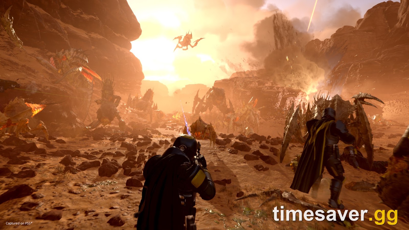 Two Helldivers fighting a dense Terminid horde at close range in a rocky canyon