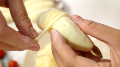 Cách làm tôm cuộn khoai tây: Vo bột khoai tây thành những cục tròn nhỏ khoảng 20gr rồi dàn mỏng ra và cuốn tôm đã ướp vào giữa, dùng tay miết để khoai nghiền ôm sát tôm, chỉ chừa lại phần đuôi để khi chiên xòe ra đẹp. Sợi khoai tây sau khi ngâm nước muối lấy ra để ráo, thấm khô và lấy khoảng 50gr bột bắp rắc đều lên từ từ để sợi khoai được áo bột và có độ kết dính. Sau đó dùng từng sợi khoai cuốn vào phần tôm vừa bọc bằng khoai nghiền.