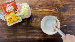 Chuẩn bị sẵn các nguyên liệu. Ức gà chọn loại đã được lọc bỏ xương, cắt miếng vừa. Ớt chuông xanh đỏ và thơm cắt hạt lựu. Hành tây cắt hạt lựu, tỏi băm nhuyễn. Chuẩn bị 2 chiếc tô sạch, mỗi tô cho vào 25gr bột chiên giòn, 1 tô giữ làm bột khô, tô còn lại thêm 40ml nước lọc rồi khuấy đều tạo thành bột nước. Đặt miếng thịt gà vào giữa túi zip hoặc màn bọc thực phẩm, dùng búa đập thịt dần cho ức gà mỏng lại giúp thịt gà được mềm hơn khi chế biến. Nhúng 2 mặt miếng thịt gà vào bột ướt sau đó nhúng tiếp gà vào bột khô sao cho bột áo một lớp mỏng.
