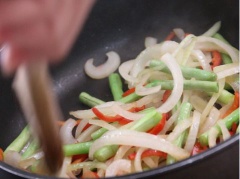 Cho 2 muỗng canh dầu vào chảo, dầu nóng cho thịt viên vừa ướp vào chiên chín vàng. Có thể đem thịt viên hấp chín, chắt ráo nước trước khi cho vào chảo chiên vàng, hơi sém. Cho 2 muỗng canh dầu ăn vào chảo, dầu nóng cho hành tây, ớt, đậu đũa vào đảo đều, thêm 2 muỗng canh nước, 1 muỗng cà phê nước mắm, muối, tiêu vào đảo đều.