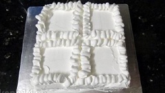 Phần kem sữa tươi còn lại cho vào túi bóp kem và trang trí như hình. Xếp những miếng xoài hạt lựu vào những ô để trống. Vậy là xong bánh gato xoài.