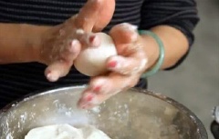 Vo đều tay đến khi viên bột tròn đều là được. Đổ mè trắng rang chín ra đĩa rồi lăn từng viên bánh vào cho mè bám đều lên bột.