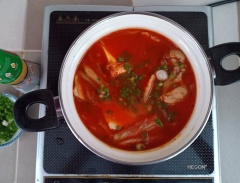 Khi hỗn hợp canh sôi lại thì hạ lửa nhỏ, đập tùng cái trứng vào, nấu chín trứng là nồi canh đã hoàn tất. Rắc hành lá và cho dầu mè.