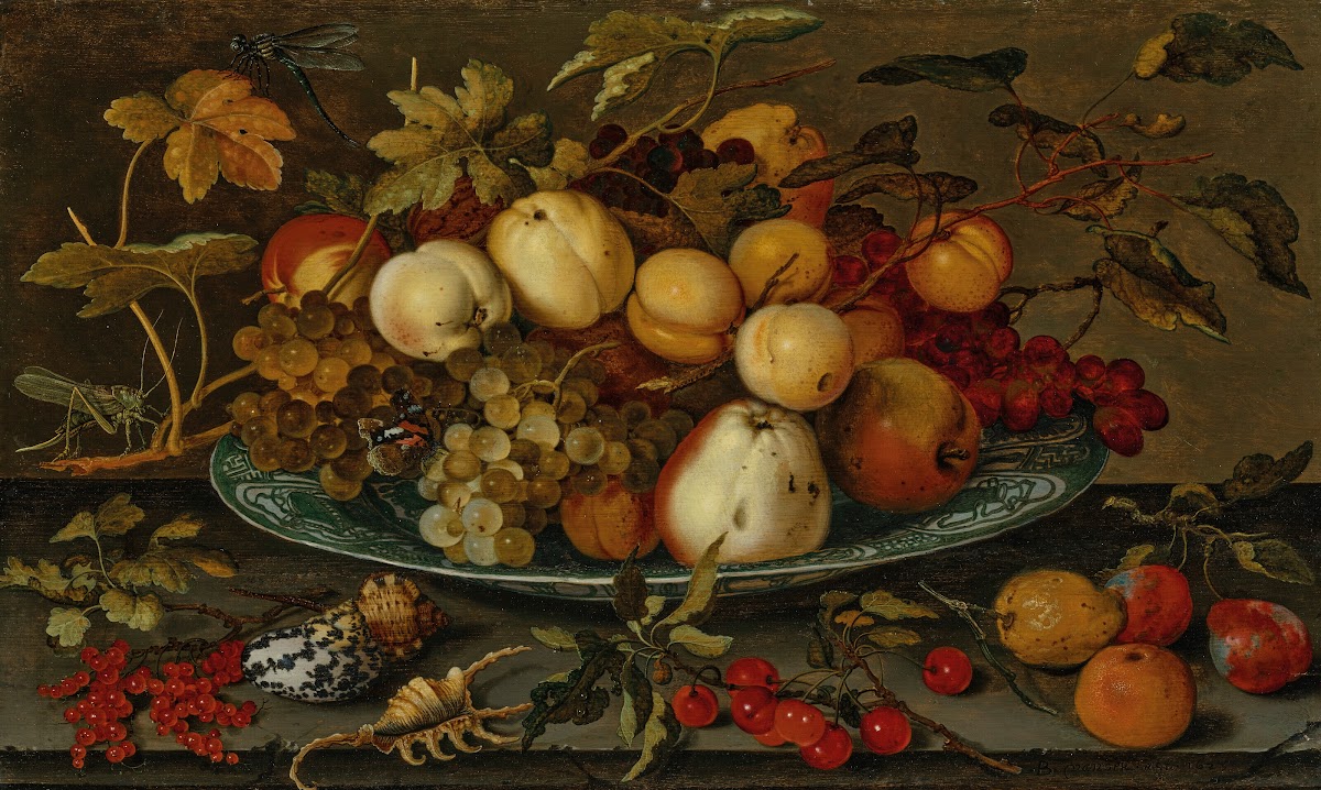 Grapes peaches apples and plums in a wan li bowl on a ledge with shells a grassh
