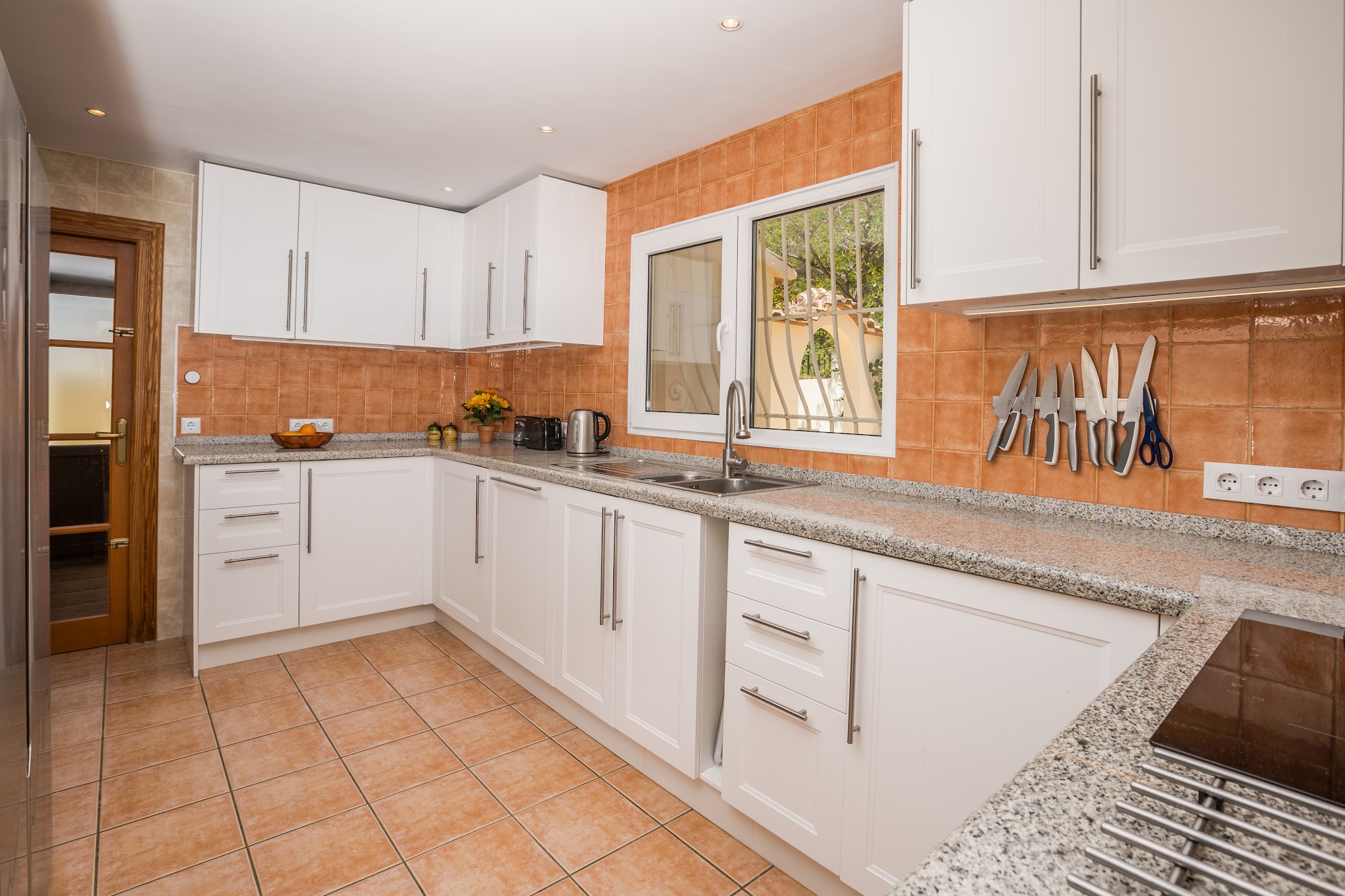 White fitted kitchen with garden window
