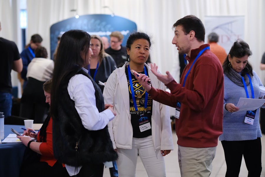 Attendees in conversation on the floor at Colorado RE•CON