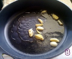 Làm nóng chảo với 1 muỗng canh dầu ăn rồi cho 2 tép tỏi còn lại vào phi thơm. Thêm sườn vào đảo cùng 1/4 muỗng cà phê đường, 1/4 muỗng cà phê muối trong khoảng 1 phút. Lăn sườn vừa chiên qua đĩa đậu phộng đã giã là xong.