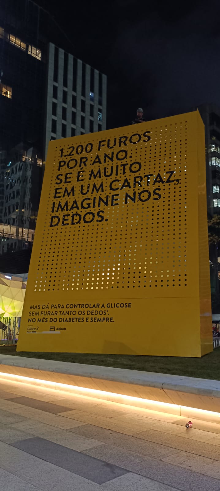 Vista frontal do painel da Abbott para a campanha do Libre 2, instalado em um ambiente urbano noturno.
