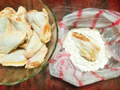 Cho 3 muỗng canh bột mì, 1/2 muỗng cà phê bột nở vào túi nilon sạch sau đó trộn đều, tiếp theo cho cánh gà đã ướp gia vị vào cùng rồi túm chặt túi, xóc đều cho cánh gà bám đều 1 lớp bột bên ngoài.