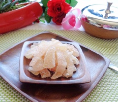 Xếp mứt cùi bưởi lên khay sau đó phơi nắng khoảng 2 tiếng cho mứt khô ráo. Khi mứt cùi bưởi được phơi nắng, cho từng miếng mứt vào chén đường (50gr đường) cho đường bám quanh miếng mứt.