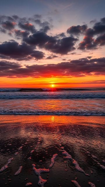 Fiery sunset over ocean with crashing waves and reflective wet sand - Free mobile Wallpaper