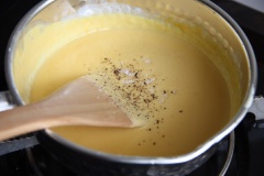 Đun đến khi hỗn hợp bám 1 lớp mỏng ở muôi thì cho thêm 100gr phô mai Cheddar bào sợi vào khuấy cho tan. Nêm nếm lại với chút muối tiêu cho vừa miệng.