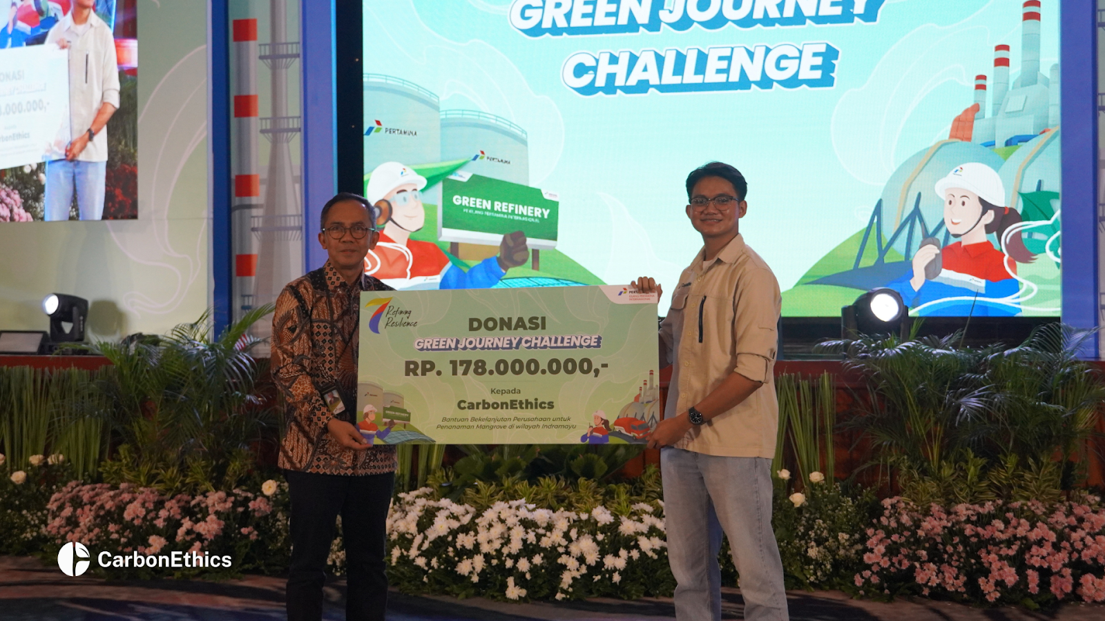 Nehemia Irel, Associate Business Team of CarbonEthics, receiving a symbolic donation for the Green Journey Challenge with PT Kilang Pertamina Internasional.