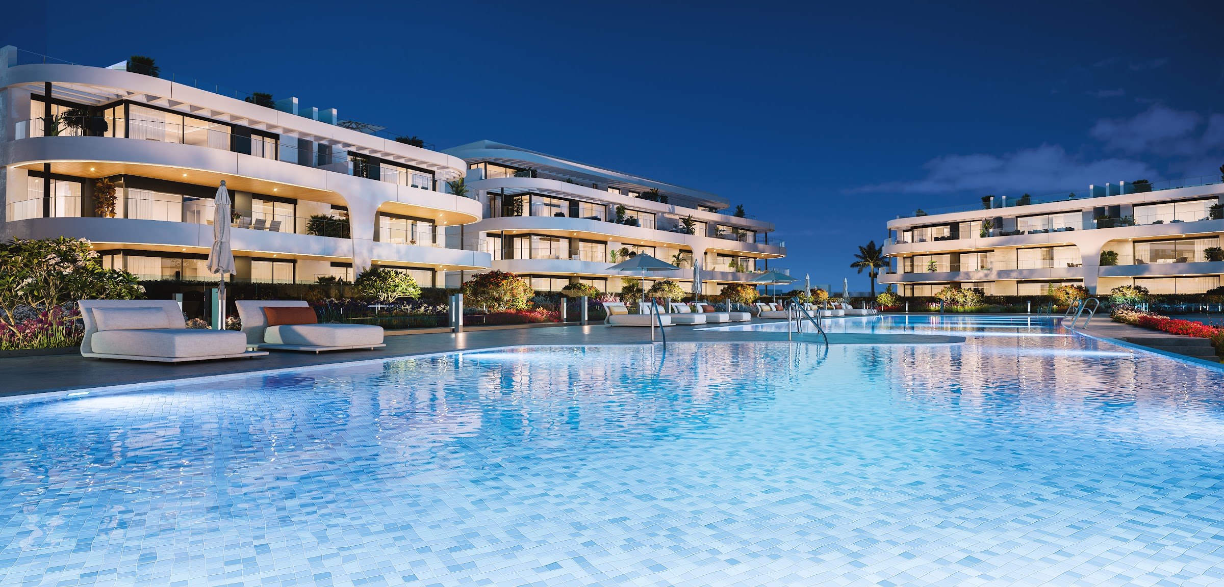 NAYA Residences — illuminated facades and pool at dusk