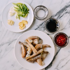 Tôm tươi bỏ đồ và chân tôm, chè đôi sống lưng, lấy bỏ chỉ đen rồi rửa sạch tôm, thấm khô nước. Tỏi bóc vỏ cắt láy mỏng. Hành lá cawsy lát chéo để riêng phần đầu hành và phần lá.