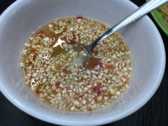 Pha nước chấm bánh tằm bì: Cho 2 muỗng canh nước mắm, 2 muỗng canh đường vào chén khuấy tan đường. Sau đó thêm ớt và tỏi băm, vắt thêm chanh vào khuấy đều lần nữa.