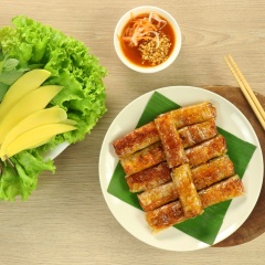 Trình bày chả lụi đã nướng chín ra dĩa,được cuốn dùng kèm với xà lách, rau thơm, dưa leo bào và xoài xanh, chấm với nước chấm tương đậu.