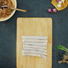 Xếp 2 lớp bánh tráng bò bía lên nhau, phết lên trên 1 lớp nhân mỏng sau đó cuốn lại chặt tay. Làm lần lượt cho đến hết số nhân và bánh tráng.