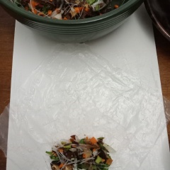 Cuốn chả giò : đặt bánh tráng lên thớt, cho nhân vào và cuộn chặt tay. Làm tương tự cho hết nguyên liệu.