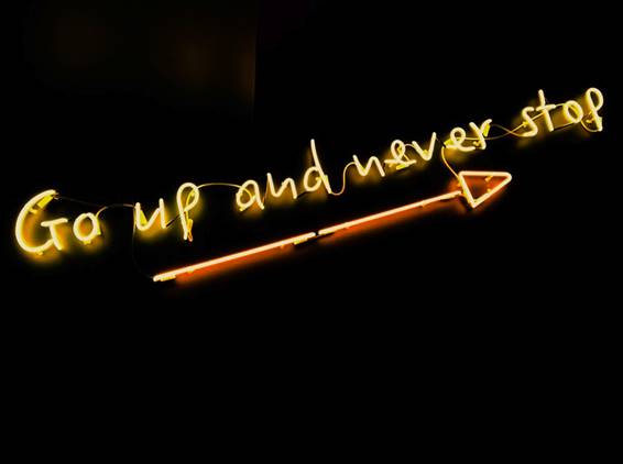 Neon sign reading 'Go up and never stop'