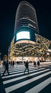 Modern Urban Building with Illuminated Green Facade at Night