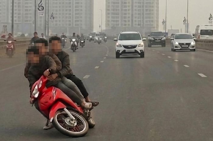 Xe máy chở ba người lạng lách ở làn ô tô, ngã trên cầu Nhật Tân - Báo Xây Dựng