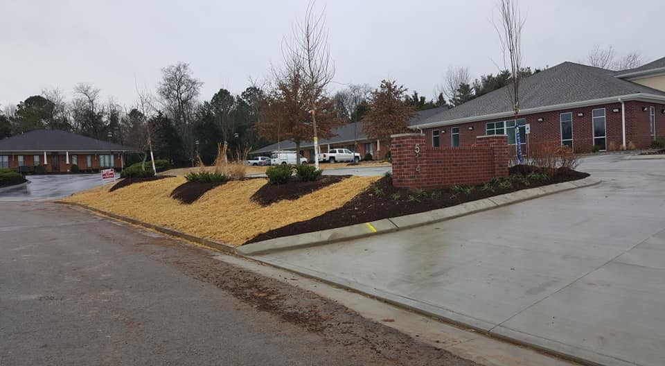 Exterior view of a brick health clinic building in Middle Tennessee with a grey roof and landscaped mulch beds.