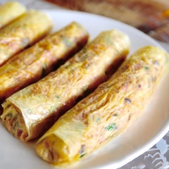 Trải bánh tráng lên thớt, múc nhân cho vào giữa, gấp 2 bên mép lại rồi cuốn chặt tay. Làm như vậy đến khi hết tất cả nguyên liệu. Cho chả vừa cuốn vào nồi hấp chín khoảng 15 phút. Sau đó lấy ra, đợi nguội một chút thì lăn chả qua một lớp lòng trắng trứng rồi một lớp bột bắp cho áo thât đều.