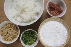 Sơ chế tất cả các nguyên liệu: tôm khô ngâm mềm, băm nhỏ, củ cải bào nhỏ. Lạp xưởng và hành ngò cắt nhỏ. Chuẩn bị khuôn để hấp bánh, quết đều dầu ăn và lót giấy nến xuống dưới. Củ cải sau khi bào nhỏ, cho vào nồi cùng với khoảng 400ml nước, đun ở lửa lớn đến khi sôi thì hạ nhỏ lửa, đun chừng 15 phút thì đổ ra một âu lớn, để nguội bớt.