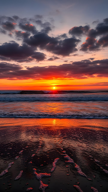 Fiery sunset over ocean with crashing waves and reflective wet sand - Free mobile Wallpaper