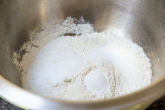 Làm nóng lò nướng ở nhiệt độ là là 180 độ C (350 độ F). Cho bột baking soda, bột nở và muối vào bột mì, dùng muỗng trộn đều. Tiếp theo, các bạn cho bơ đã làm mềm, đường nâu, đường trắng vào chung một tô.