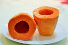 Đu đủ chọn quả chín cây, tươi ngon, vỏ vàng đều. Các bạn gọt vỏ, cắt đôi quả đu đủ theo chiều ngang, bỏ hạt, cắt một ít ở phần đầu quả để có thể dựng đứng 1/2 quả đu đủ.