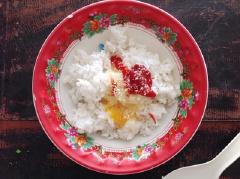 Đập một quả trứng gà vào tô cơm, cho thêm 2 muỗng cà phê tương cà chua và 1 muỗng cà phê hạt nêm vào tô cơm trứng, trộn đều cho thấm.
