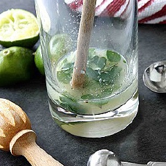 Cho lá bạc hà, 1 muỗng canh nước cốt chanh và 1 muỗng canh đường vào ly. Dùng muỗng nghiền thật kỹ cho lá bạc hà nát ra và tiết nhiều dầu thơm.