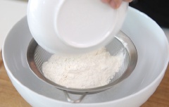 Rây đường với bột mì vào chung một bát. Cho trứng vào đánh đều. au đó cho sữa và dầu ô liu vào khuấy đều.