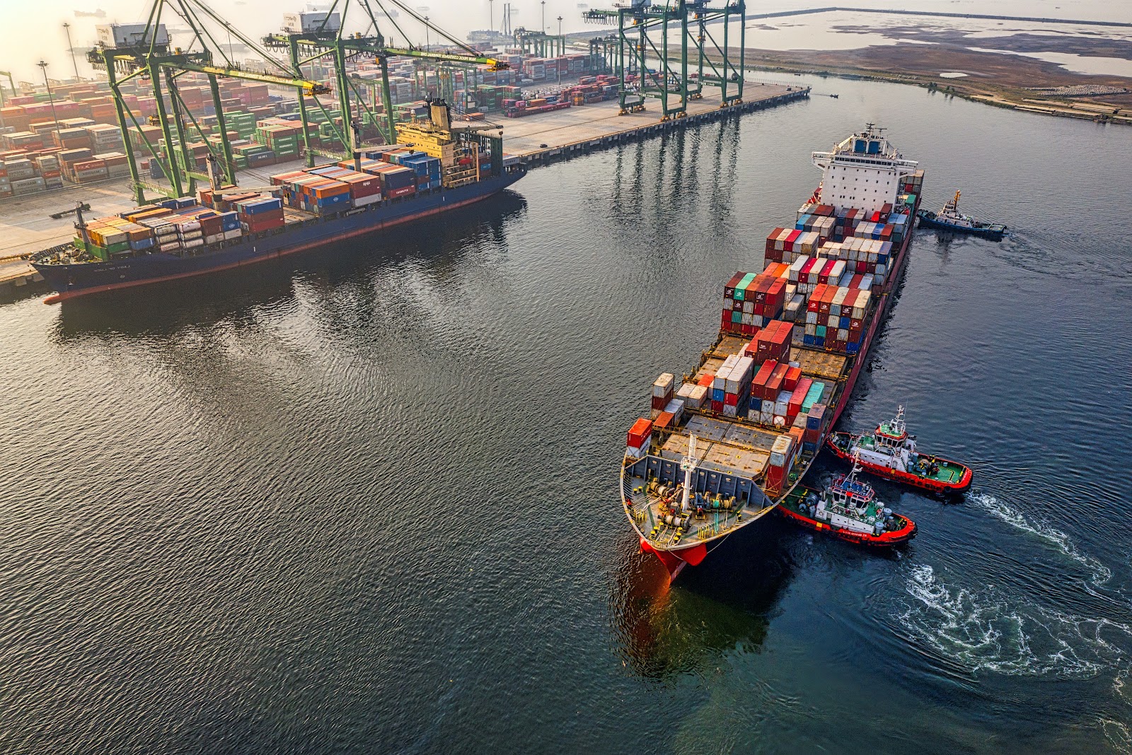 Port with colorful containers and freighter ships in daylight