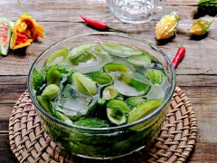 Đun sôi nồi nước, chần nhanh khổ qua đã cắt vào nước, sau đó cho khổ qua đã trụng vào 1 thau nước sạch có bỏ đá lạnh để giữ nàu xanh và độ giòn. Sau khi nước nguội vớt khổ qua ra, rửa lại thêm lần nữa với nước lọc rồi để thật ráo.