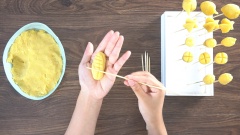 Để đậu xanh nguội bớt rồi đem tạo hình thành những loại trái cây rau củ quả tùy thích như cà tím, quả bắp, măng cụt, cà rốt,... Sau khi tạo hình thì bạn cắm bánh vào những que xiên tre rồi cắm cố định xiên vào miếng mút xốp. Tiếp theo là đến bước tô màu cho những loại rau củ quả này. Pha màu thực phẩm với 1 ít nước và tô trực tiếp lên những chiếc bánh đậu xanh màu sắc phù hợp.