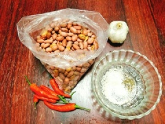 Tỏi bóc vỏ rồi băm nhỏ, ớt sừng cũng băm nhỏ. Cho đậu phộng vào chảo, bật bếp nhỏ lửa và rang cho tới khi đậu phộng chín là được. Sau đó, bạn cho đậu phộng ra đĩa.