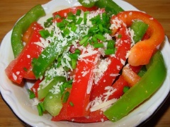 Phô mai parmesan bào vụn, rắc lên trên tô salad ớt. Cuối cùng cho hành lá vào, trộn đều là món salad ớt chuông đã xong rồi.