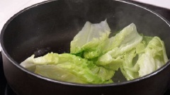 Đun nóng 1 muỗng canh dầu ăn, cho lá xà lách vào đảo đều, thêm 1/2 muỗng cà phê đường nâu, xào khoảng 1 phút cho cải mềm thì cho ra đĩa để riêng.